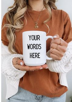 a woman holding a coffee mug with the words your words here on it in front of her