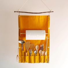 an orange hanging organizer with utensils and spoons