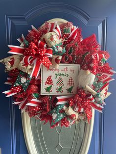 a christmas wreath on the front door with a sign that says merry with my gnome