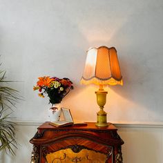 a table with a lamp on it next to a potted plant