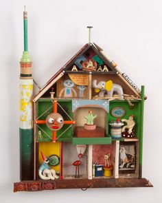 a dollhouse with lots of toys and decorations on the top shelf in front of it