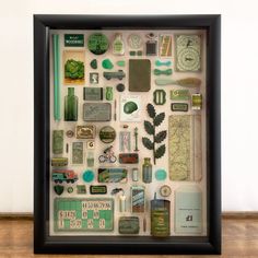 a shadow box filled with lots of assorted items on top of a wooden floor