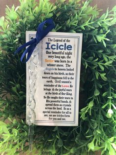 the legend of the icicle is on display in front of some green bushes with a blue ribbon around it