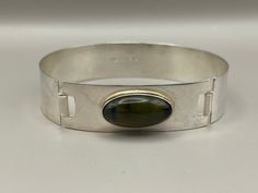 "Vintage Turun Hopea Labradorite Hinged Modernist 813 Silver Bangle Bracelet, Finland, 1964 Chunky bangle with a shimmering oval green~gold labradorite, clasps at side front Bracelet Width is 5/8\"  Length 7 1/4\" Stone Measures 7/8\" x 1/2\" Marks: TH, Finland, 813H, L7 Please check our listings for complementary rings, bracelets, earrings, necklaces & accessories" Oval Cuff Bracelet With Polished Finish, Hinged Ring, Silver Bangle Bracelet, Hinged Bracelet, Rings Bracelets, Silver Bangle Bracelets, Silver Bangle, Silver Bangles, Green Gold