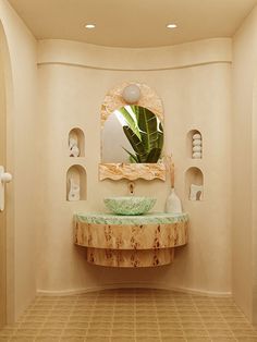 a bathroom with a sink, mirror and shelves on the wall next to each other