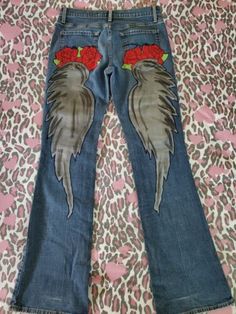 a pair of jeans with red roses on them