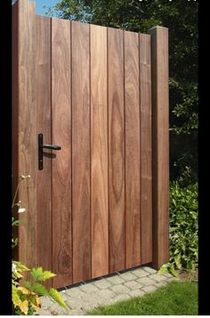 a wooden gate in the middle of a garden