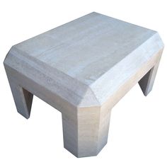 a white concrete bench sitting on top of a wooden table