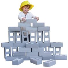 a young boy in a yellow hat is playing with blocks