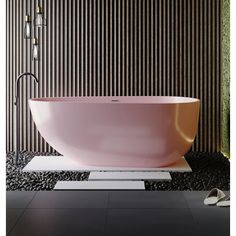 a pink bath tub sitting on top of a black floor