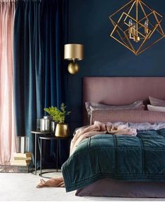 a bedroom with blue walls, gold accents and green bedding in the center is a chandelier