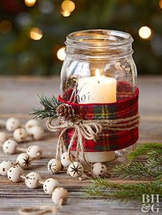 a mason jar filled with christmas decorations and a lit candle