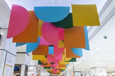 the ceiling is decorated with multicolored paper shapes hanging from it's sides