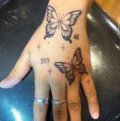 a woman's hand with two butterflies on it and the number thirteen is shown