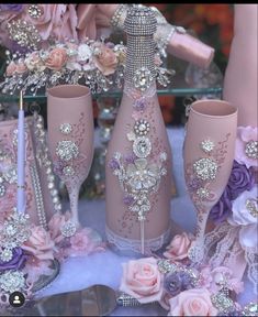 three pink vases are sitting next to each other on a table with flowers and pearls