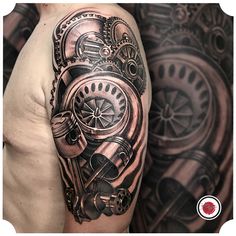 a man's arm with a clock and gears tattoo design on the left shoulder