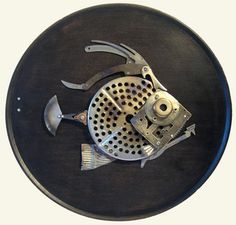 a metal fish on top of a black plate