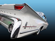 the rear end of an old car with chrome trims and tail lights on it