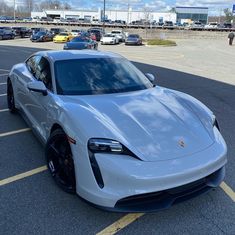 a white sports car parked in a parking lot