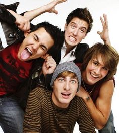 a group of young men standing next to each other in front of a white background