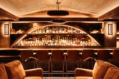 a dimly lit bar with chairs and bottles on the shelves