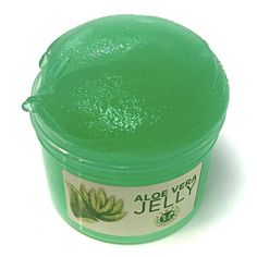 a jar of jell sitting on top of a white table next to a green container