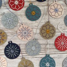 some ornaments are hanging on a wooden table with white boards and wood planks in the background