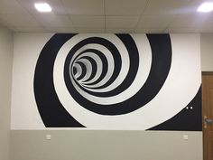 a large black and white painting on the side of a wall in an office building