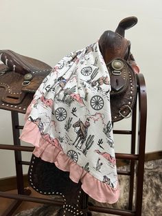 a saddle with a blanket on top of it next to a cowgirl's purse