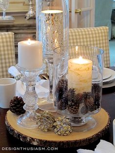 a table topped with candles and pine cones