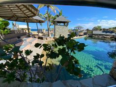 an outdoor swimming pool with umbrellas and lounge chairs next to the water's edge