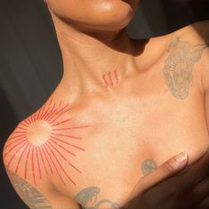 a woman with tattoos on her chest and arm