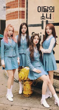 three girls in blue dresses standing next to a yellow fire hydrant