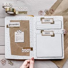 an open planner with paper and washi tape on it, next to other items