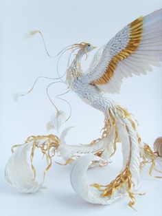 a white and gold bird with wings spread out