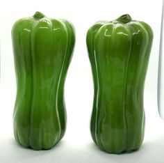 two green peppers sitting next to each other