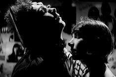 black and white photograph of two people with one holding the other's head up