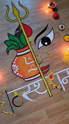 an artistic painting on the floor with candles and lights in the background for diwaling