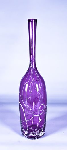 a purple vase sitting on top of a white table