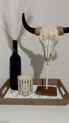 an animal's head is displayed on a tray next to a candle and bottle