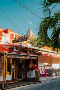 a small store on the side of a street with palm trees in front of it