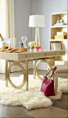 a room with a table, chair and purse on the floor in front of a window