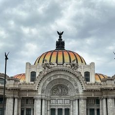 a large building with a dome and statues on top