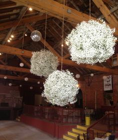 an image of a wedding venue with flowers hanging from the ceiling and chandeliers