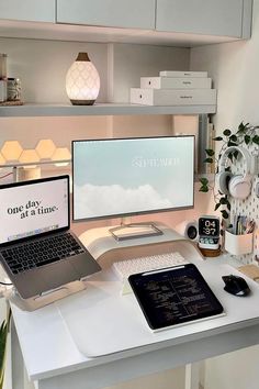 a desk with a laptop, monitor and keyboard on it