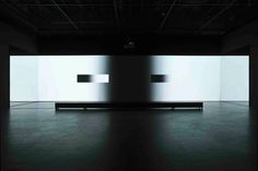 a black and white photo of a bench in an empty room