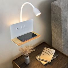 a desk with a laptop on it and a lamp next to it that is attached to the wall