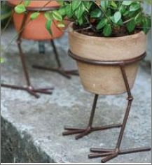 two potted plants are standing on legs with colored pencils in them