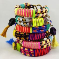 a stack of colorful bracelets with tassels and beads