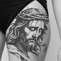 a woman's thigh with a tattoo of jesus wearing a crown on top of her head